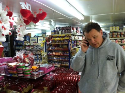 Tommy Hutcherson, inside his stocked Variety Store, talks to a vendor.